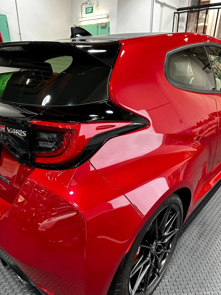 Rear quarter of the red GR Yaris with the GR Yaris badge and gloss black tail light surround